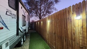 A RV with 'SALEM CRUISE LITE' branding parked beside a wooden fence with lights. - Cozy 1-bedroom recreational vehicle in fabulous Las Vegas with AC (Las Vegas)