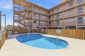 A multi-story building with a swimming pool, wooden deck, and a lifeguard tower. - Oceanfront NEW Updated Modern Condo w/ 4 Beds! (North Myrtle Beach)