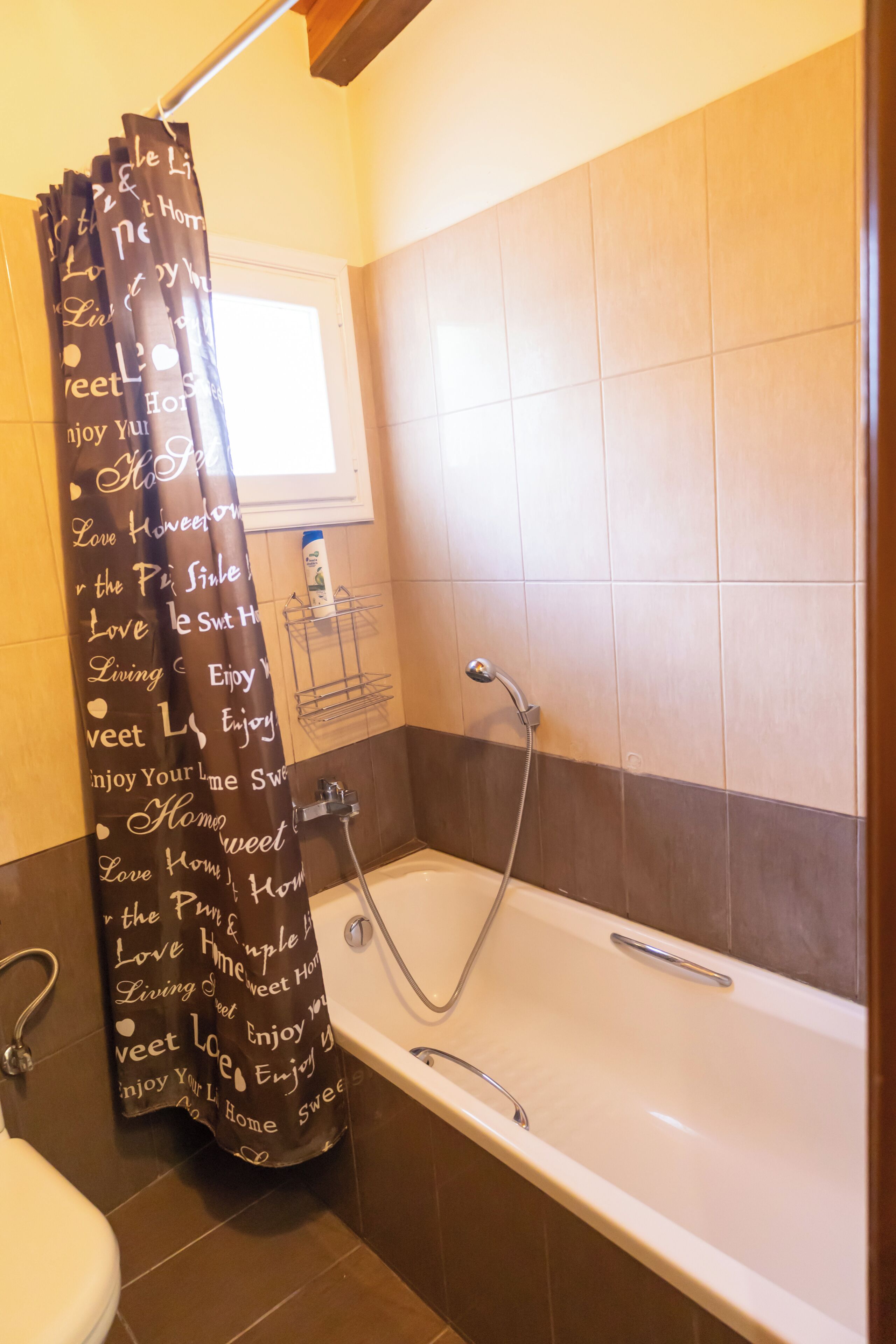 A bathroom with a bathtub, shower, and a window.