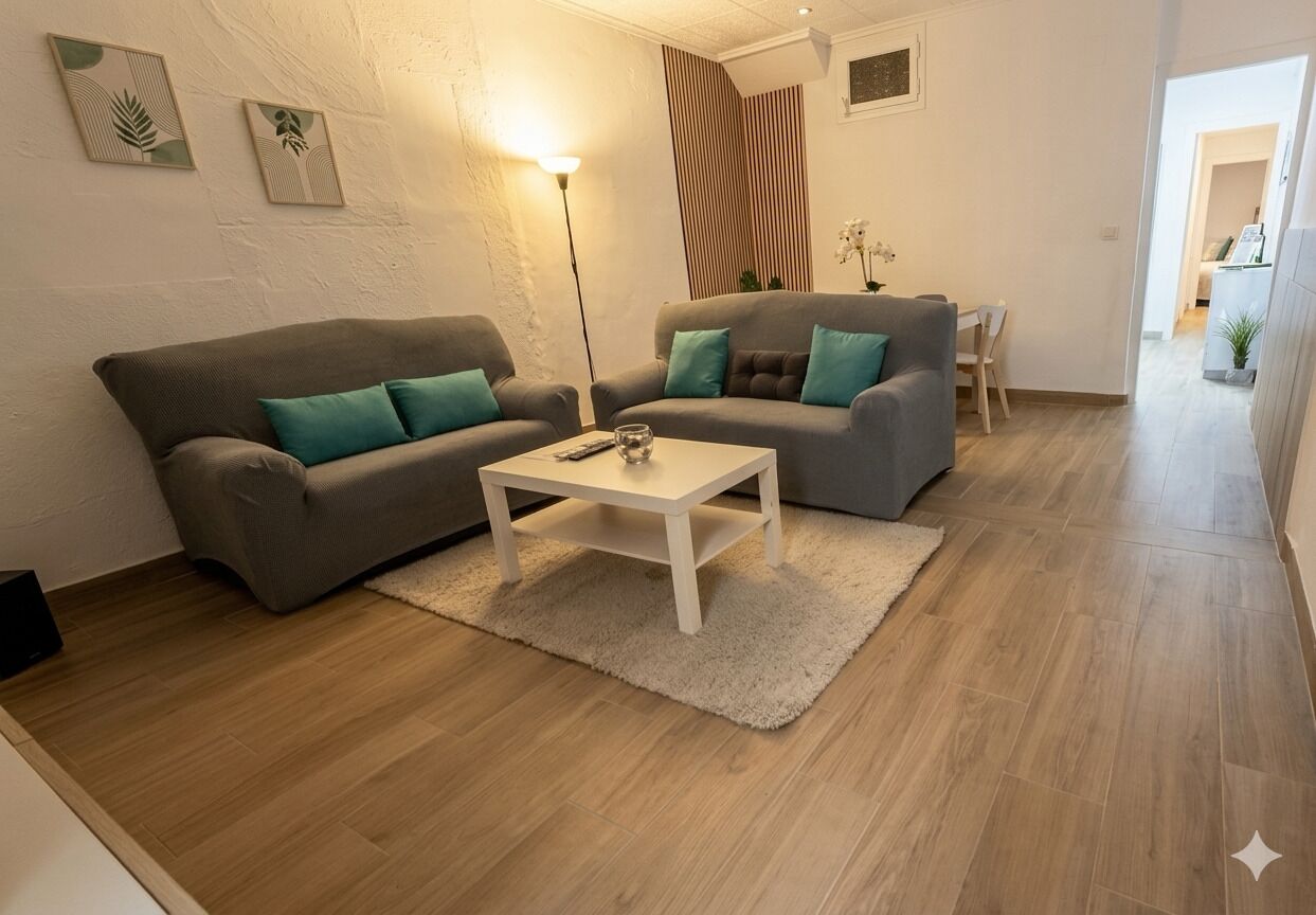 A living room with two sofas, a coffee table, a floor lamp, and a small table with a plant.