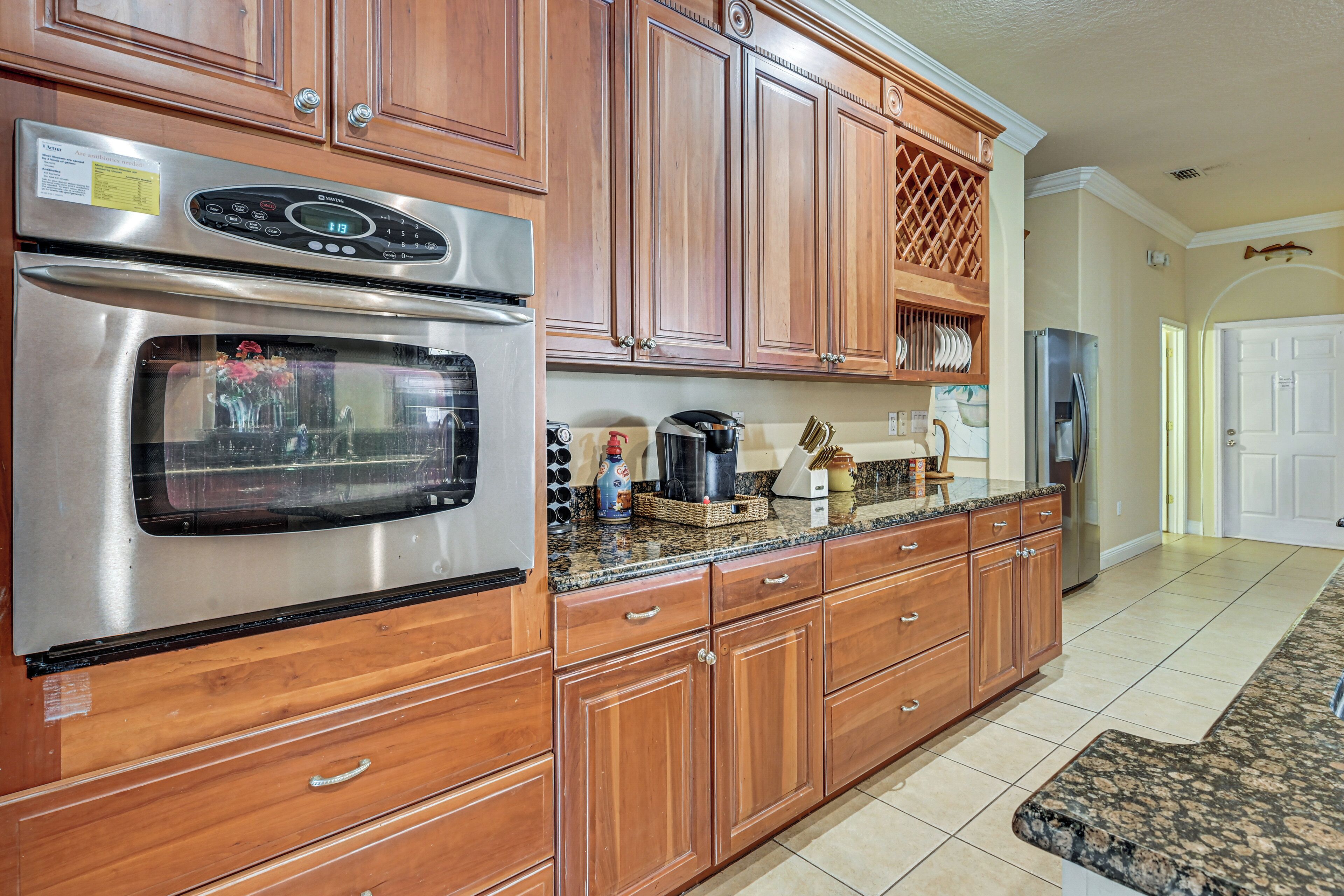 A kitchen with wooden cabinets, stainless steel appliances, and a granite countertop.