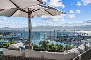 Ein Balkon mit Blick auf eine Marina, Boote und Berge.