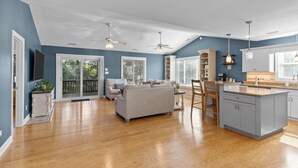 A spacious living area with a sofa, dining table, and kitchen island. - Sandpiper Hideaway - Easy Beach Access (Indian Beach)