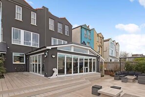 A modern house with a large patio area, a conservatory, and a garden. - Large detached period house on the Harbourside (Bristol)