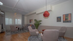 Uma sala de estar moderna com um sofá, duas poltronas, uma mesa de centro e um vaso com planta.