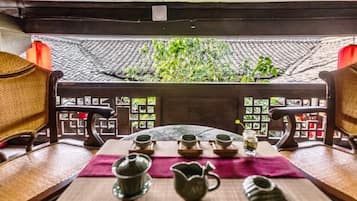A traditional tea setting with a table, chairs, and tea utensils.