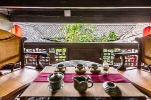 Un décor traditionnel pour la dégustation de thé, comprenant une table, des chaises et des accessoires pour le thé.
