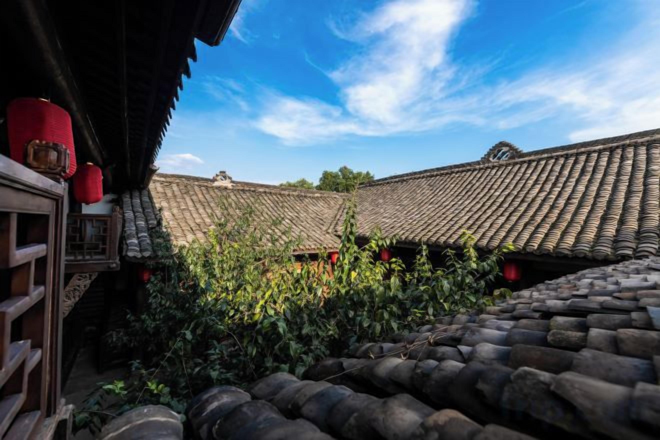 A traditional building with a tiled roof and a wooden structure to the left.