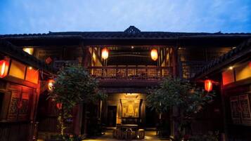 A traditional building with a balcony, wooden doors, and lanterns.