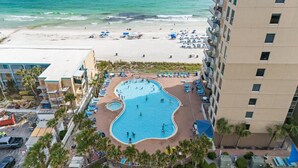 Un hotel con piscina, playa y palmeras.