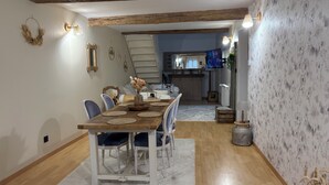 Una zona de menjador amb taula de fusta, cadires i una catifa.