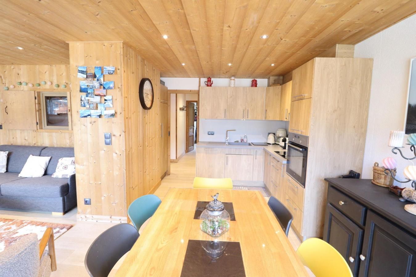 Un interior acogedor con una mesa de comedor de madera, un sofá y una zona de cocina.