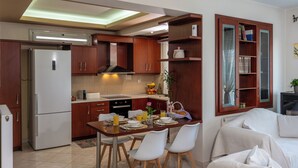 A modern kitchen with wooden cabinets, a built-in oven, and a dining area with a table set for two.