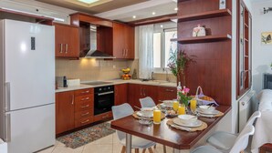 A modern kitchen with wooden cabinets, a built-in oven, and a dining area with a table set for breakfast.