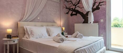 A bedroom with a bed, bedside tables, a nightstand, a canopy bed, and a wall mural.