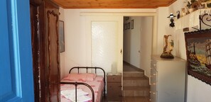 Ein Schlafzimmer mit Bett, Schminktisch, Treppe und einer Wand mit einem Schiffsbild.