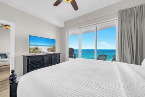 A bedroom with a large bed, a TV on the wall, a ceiling fan, and a balcony with a view of the ocean. - ☀️Stunning Gulf Front | 2 Pools + Hot Tub | Ocean Villa 2306☀️ (Panama City Beach)