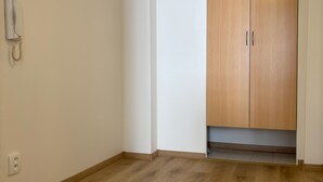 A room with wooden flooring, a white wall, and a wooden wardrobe with two doors. - Prague Deluxe City Center Apartment (Hlavní město Praha)