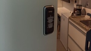 Une cuisine équipée d’une machine à expresso intégrée, d’un petit réfrigérateur et d’un plan de travail avec un évier.