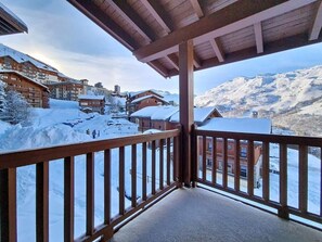 A balcony with a view of a snow-covered mountain and buildings. - 3rd floor, swimming pool, terrace, tv, ski locker, 32m², Les Menuires (Les Menuires)