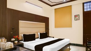 Ein Hotelzimmer mit Bett, Nachttisch und einem Beistelltisch mit Lampe.