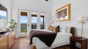 A bedroom with a bed, bedside tables, a dresser, a TV, a painting, and a view through the door. - Heavenly Views Hot Tub Games Killer Design (Sevierville)