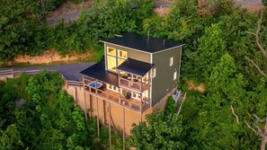 A modern two-story house with a balcony, a swimming pool, and a view of surrounding greenery. - Sunset Mountain Views · Hot Tub · Gated (Sevierville)