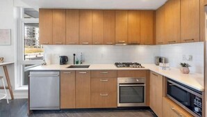 Una cocina moderna con gabinetes de madera, electrodomésticos de acero inoxidable y una isla grande.