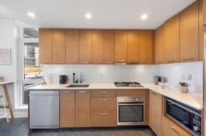 Eine moderne Küche mit Holzausstattung, Edelstahlgeräten und einer großen Kochinsel.