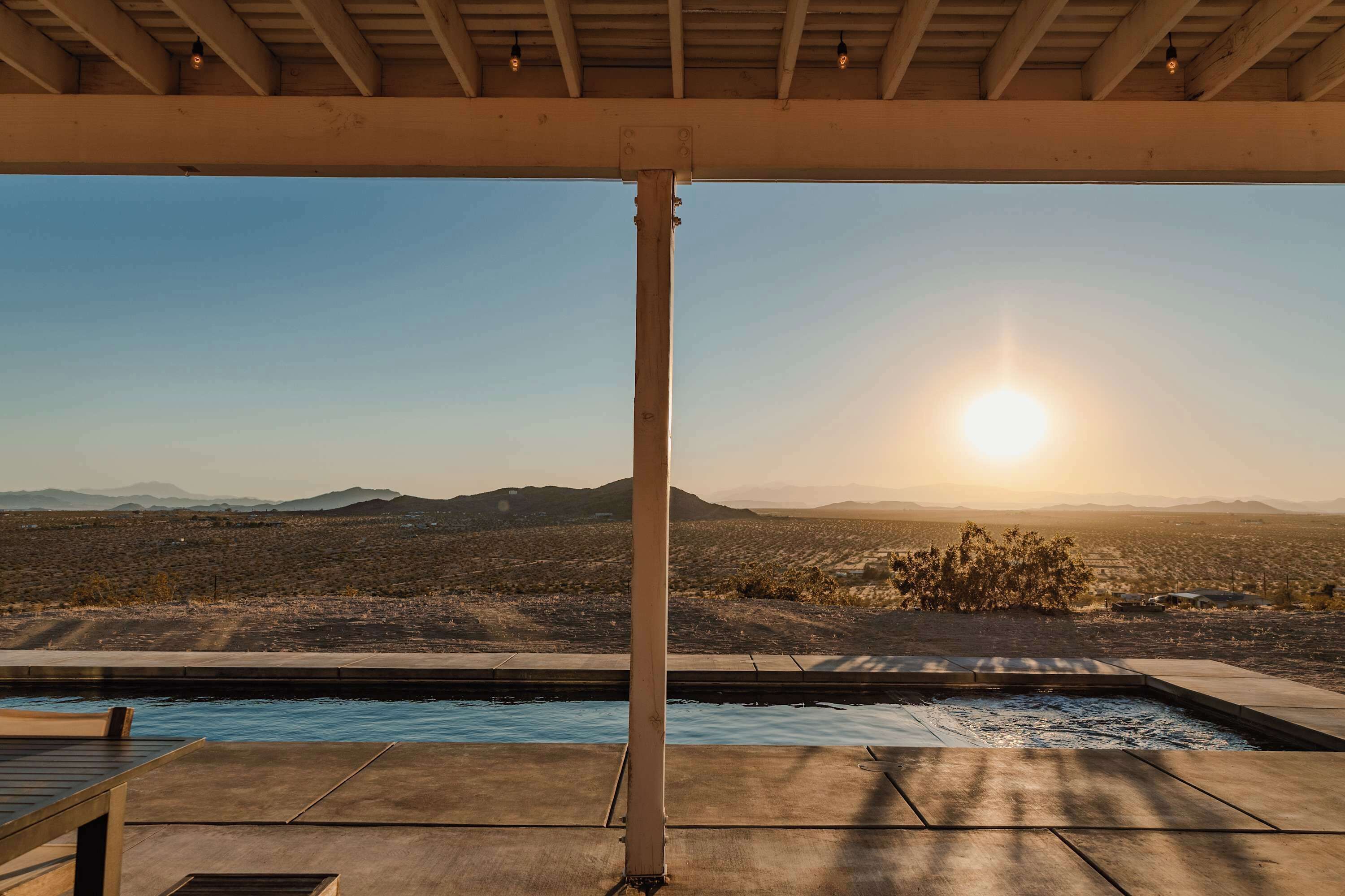 A pool with a view of mountains and a clear sky.