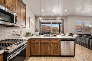A modern kitchen with wooden cabinets, stainless steel appliances, and a central island. - Ocotillo Springs 53, Private Pool, Spa, Resort Amenities (Santa Clara)