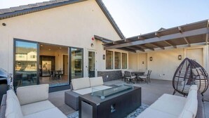 A modern outdoor patio with a glass enclosure, comfortable seating, and a fire feature. - Ocotillo Springs 53, Private Pool, Spa, Resort Amenities (Santa Clara)
