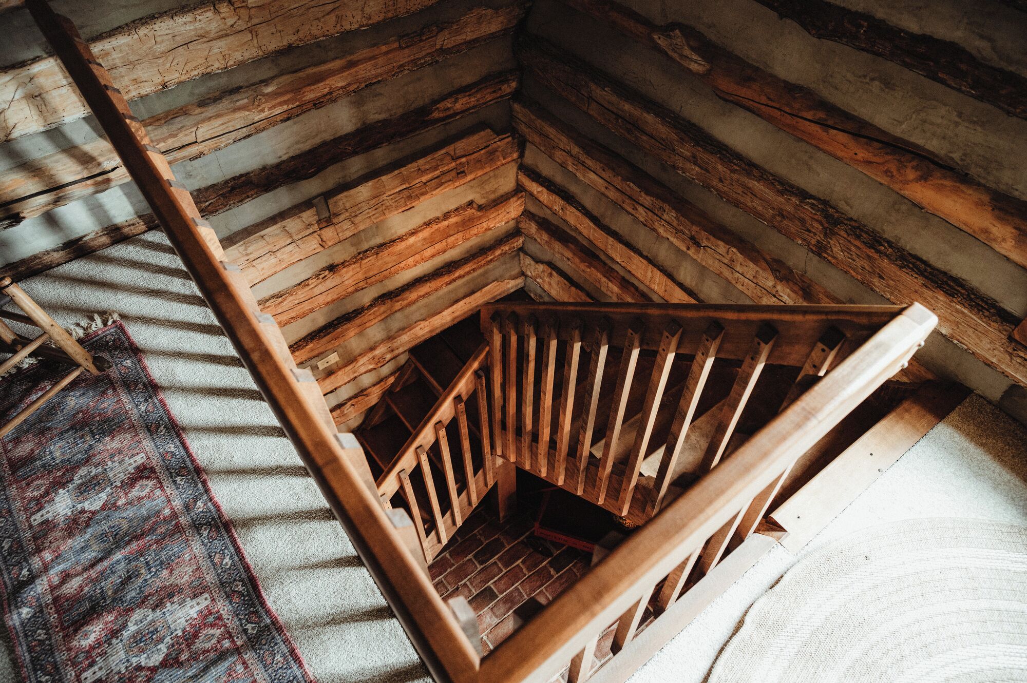 A wooden staircase with a handrail leading to a lower level.
