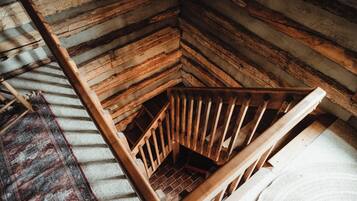 A wooden staircase with a handrail leading to a lower level.
