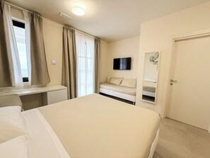 Chambre Quadruple Deluxe, patio, vue jardin | Coffres-forts dans les chambres, rideaux occultants, Wi-Fi gratuit