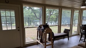 A room with large windows, a wooden bench, a table, and a rug with the word 'HOWDY' on it. - Cowboy On The Water at Lake Palo Pinto. Private Dock, New Remodel. Howdy Y'all. (Gordon)
