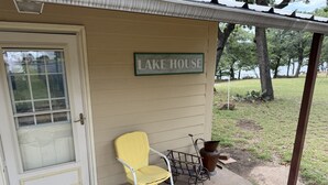 A small building with a sign reading 'LAKE HOUSE' and a yellow chair outside. - Cowboy On The Water at Lake Palo Pinto. Private Dock, New Remodel. Howdy Y'all. (Gordon)