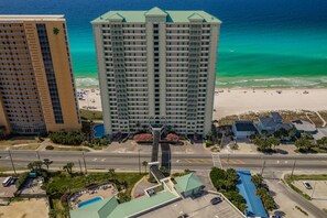 Ein Hochhaus-Hotel mit Pool, Meerblick und Parkplatz.