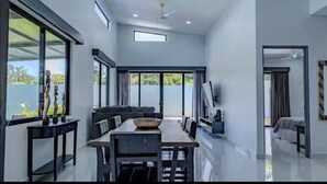 Ein modernes Interieur mit Essbereich, einer Couch und einem Fernseher.