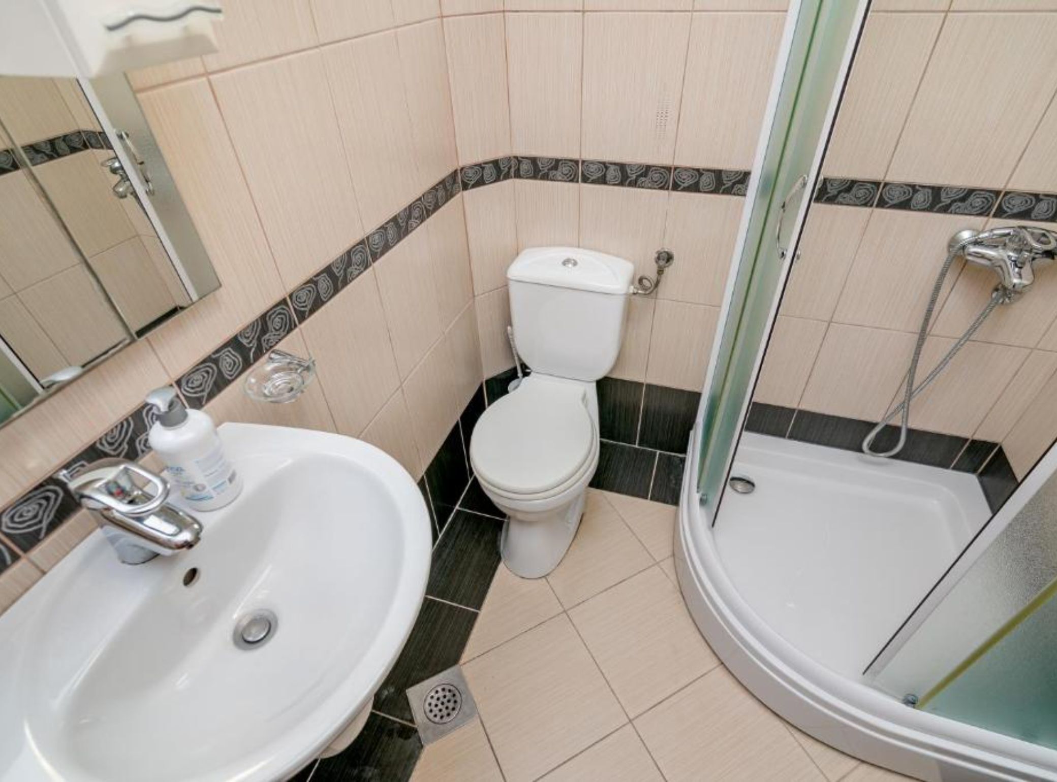 A bathroom with a sink, toilet, and shower.