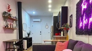 Una sala de estar moderna con un sofá seccional gris, una mesa de centro redonda y una alfombra estampada.