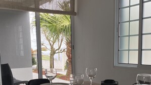 A dining table set with plates, glasses, and cutlery, with chairs around it.