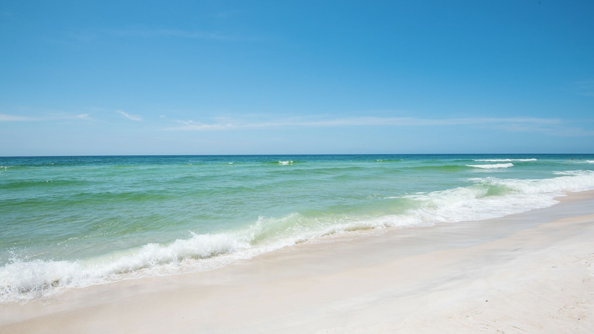 Una playa con agua turquesa cristalina y una orilla arenosa.