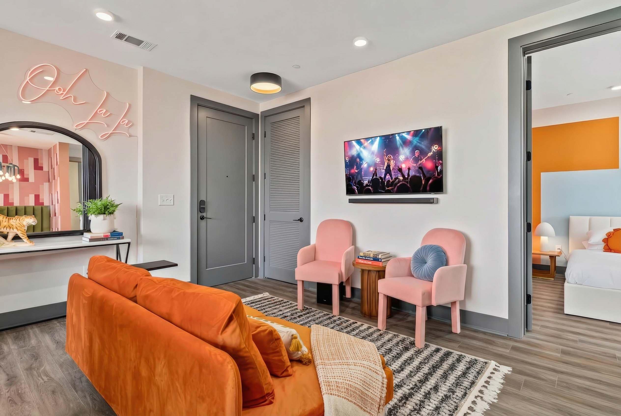 Living room with wall-mounted TV and the neon sign glow creates the vibe for a low-key evening in between honky-tonk rounds