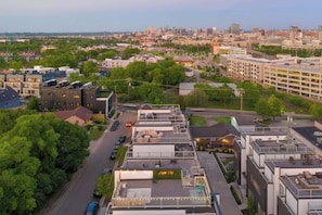 A modern hotel with a rooftop terrace, a parking garage, and a view of the city skyline. - Rooftop retreat with game room and 4 ensuite bedrooms near Centennial Park (Nashville)