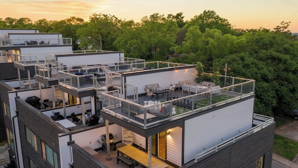 A multi-story building with outdoor terraces, balconies, and a rooftop deck. - Nashville home with skyline decks, media room, sleeps 12 (Nashville)
