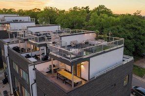 A multi-story building with outdoor terraces, balconies, and a rooftop deck. - Rooftop retreat with game room and 4 ensuite bedrooms near Centennial Park (Nashville)