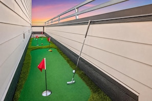 A miniature golf course with artificial turf, flags, and golf balls. - Nashville house sleeps 12, 2 decks, media room & 5 baths near Centennial Park (Nashville)