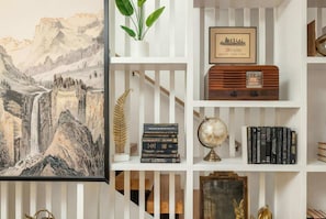 A bookshelf with books, a globe, and decorative items. - Nashville house sleeps 12, 2 decks, media room & 5 baths near Centennial Park (Nashville)