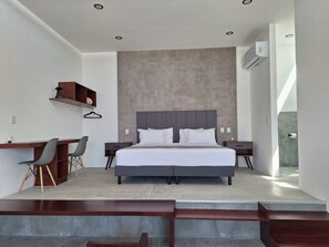 Quarto moderno com uma cama grande, uma escrivaninha e uma cadeira.